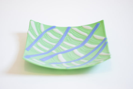 Mint green square Glass bowl with five curved lines emitating from the corner of the bowl with white lines between them