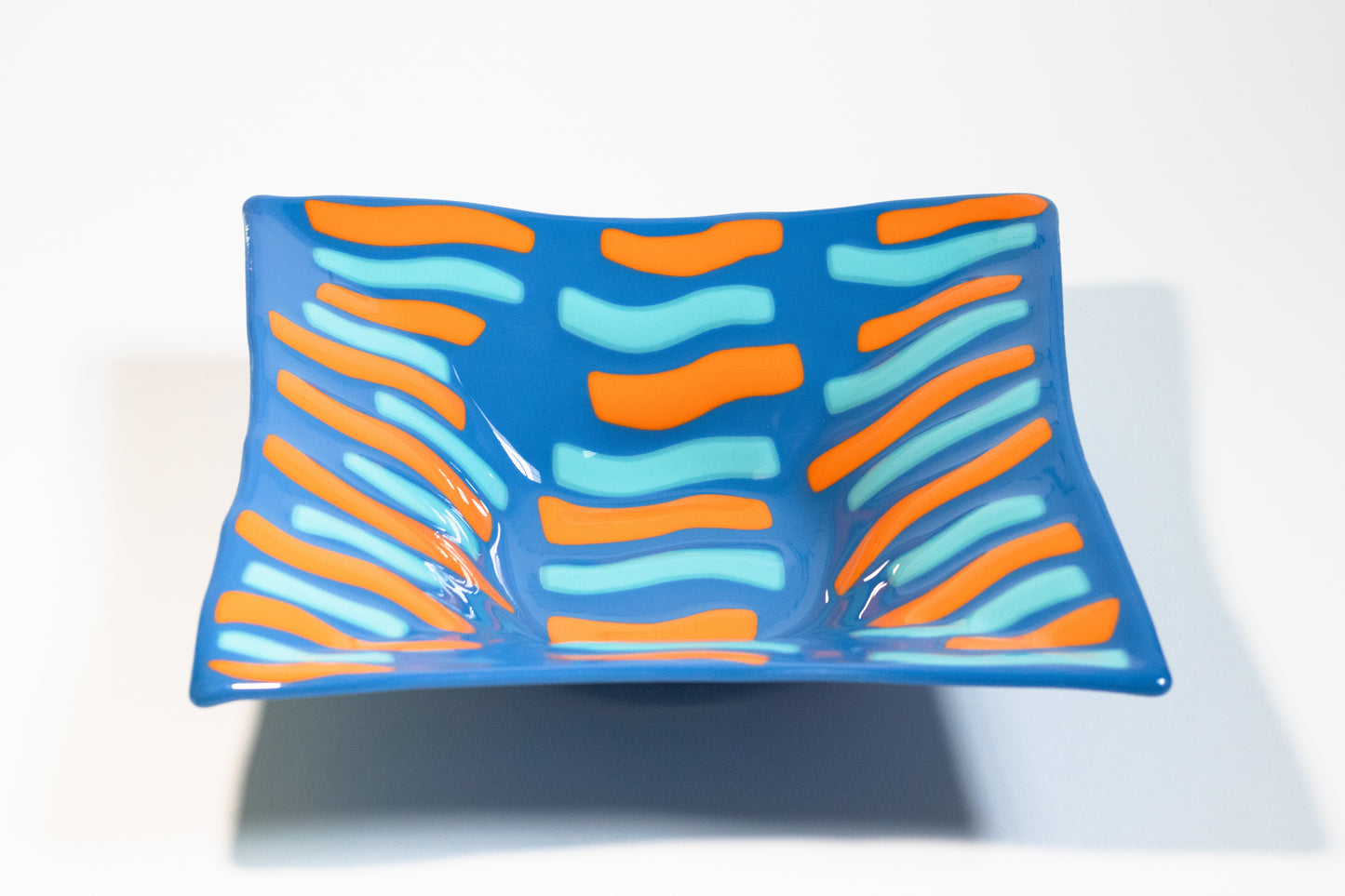 blue glass bowl with orange and light blue alternating stripes