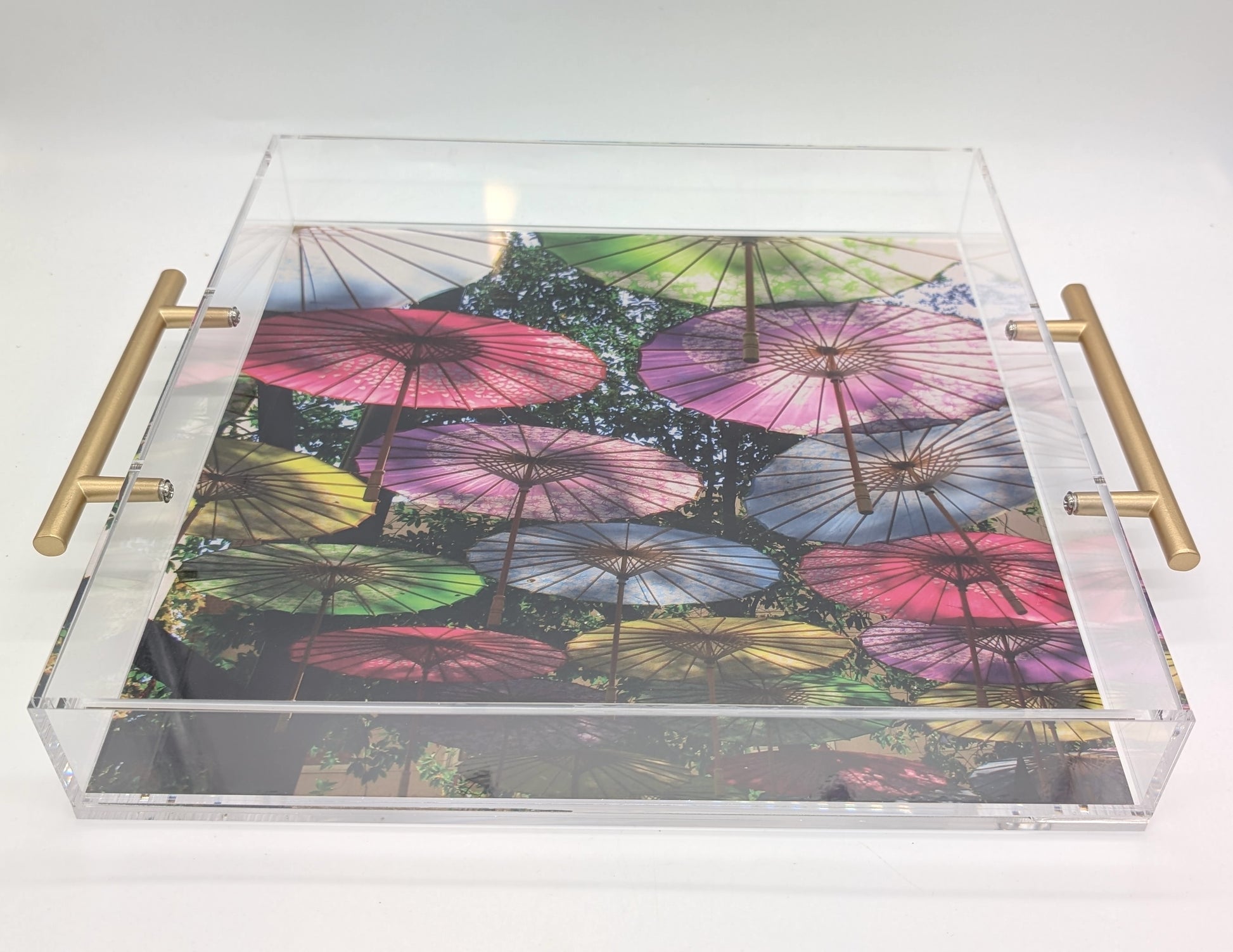 acrylic tray with gold handles and a colorful umbrella design