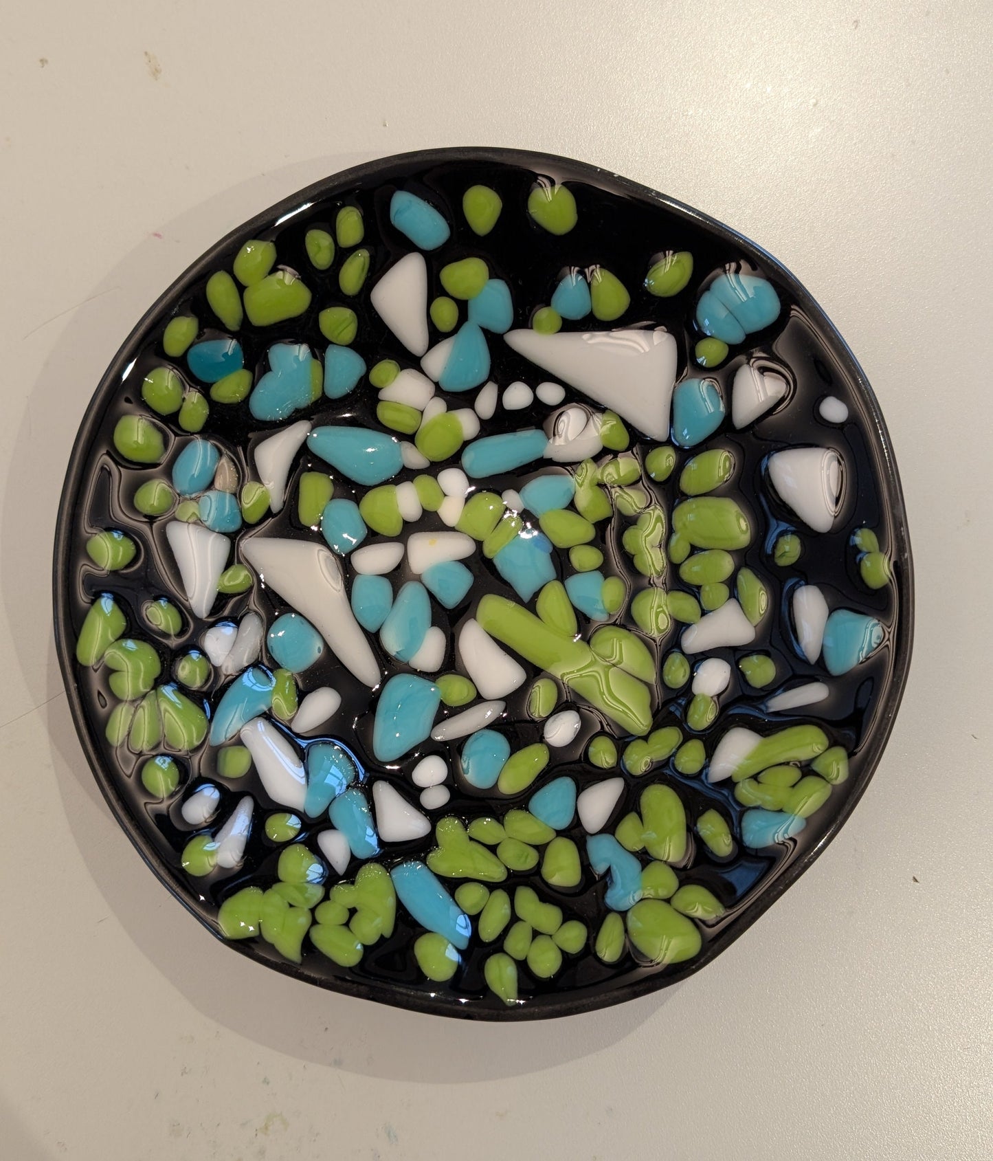 black bowl with spots of green, blue, and white