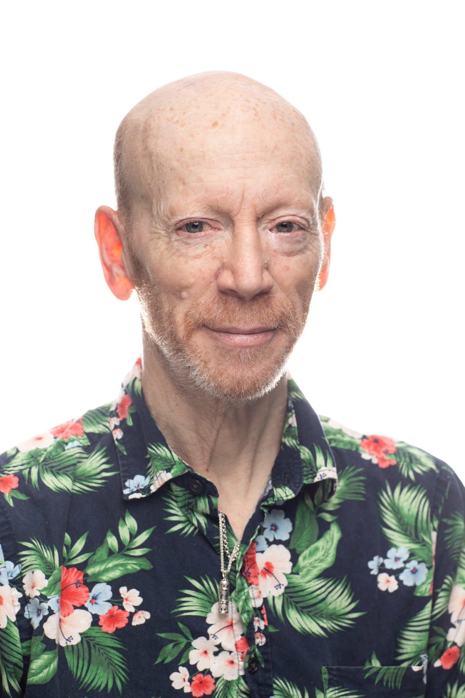 picture of bald man with facial hair wearing Hawaiian style shirt 