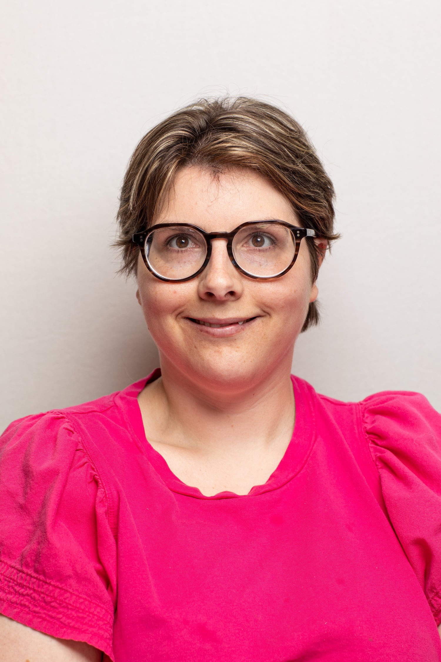 picture of young woman wearing glasses and a pink blouse