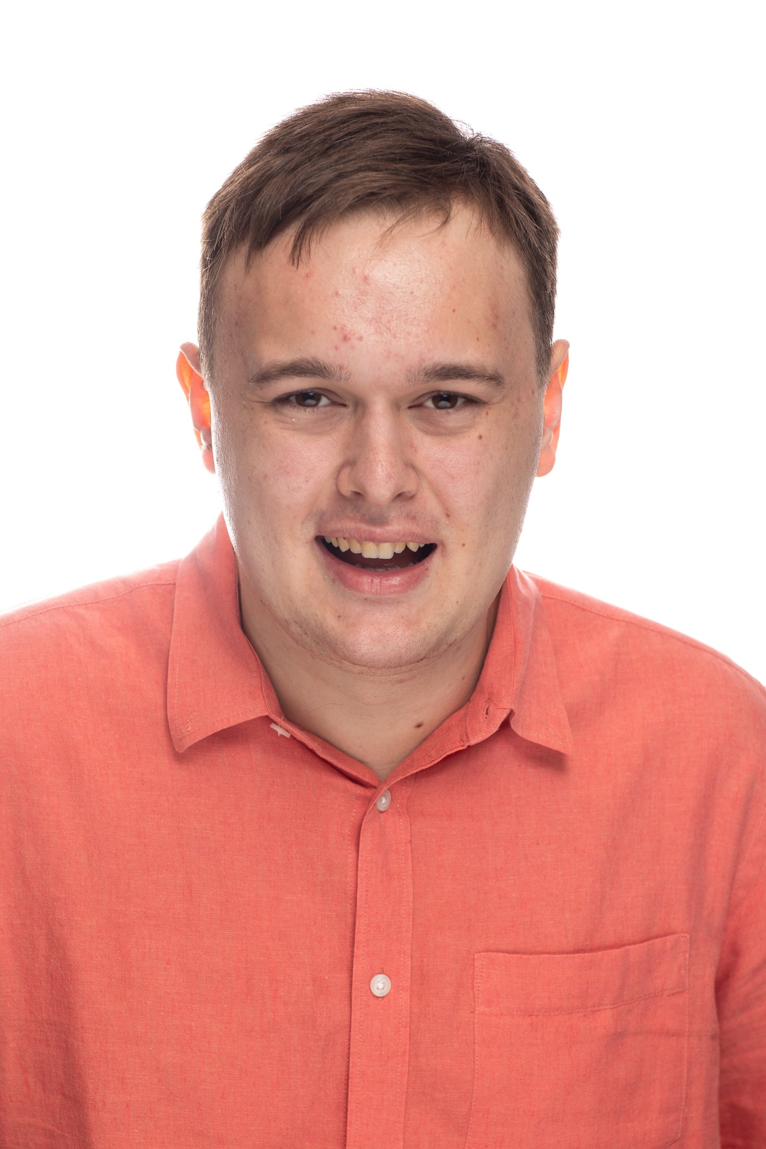 picture of young man wearing a salmon colored polo