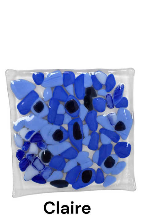 Handcrafted fused glass art tray, it features a captivating, dense mosaic of smooth glass pieces in varying shades of blue—ranging from pale sky blue to deep cobalt—creating a serene, water-like effect on a clear glass base.

Medium: Fused Glass

Size: Approximately 6" x 6"

Year: 2026