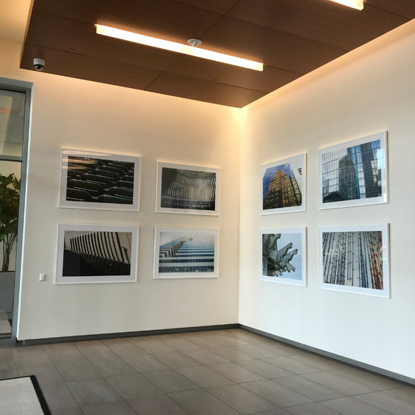 eight celebration company artist photographs displayed on two walls in the corner of a large room.
