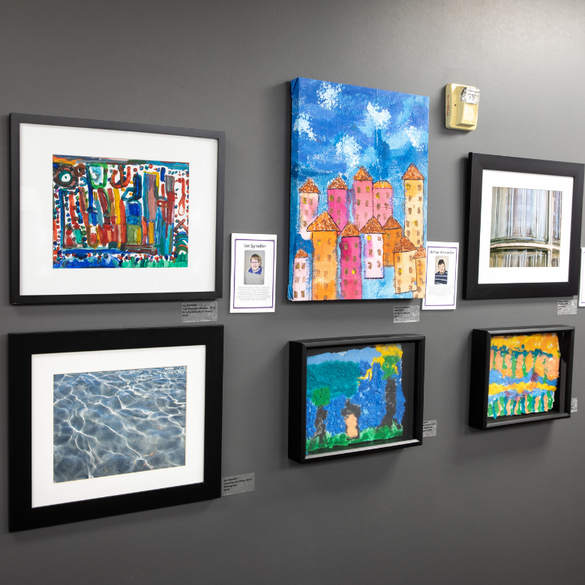 six colorful celebration company art pieces displayed on a dark grey wall.