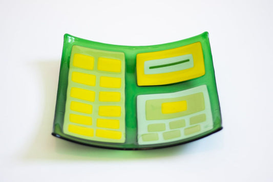 Green glass square bowl with various shades of green rectangles and squares within 