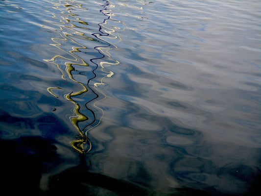 Photograph of ripples of water and with a reflection of a wavey line