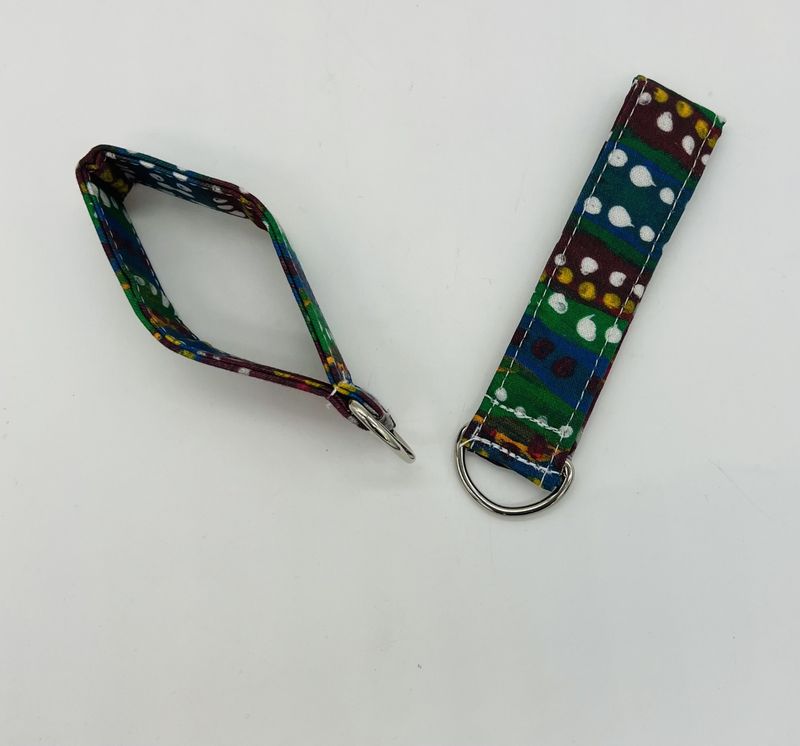 key chain of a Painting with alternating rows of blue, green, red, yelow and silver with white, red, and yellow lines on top