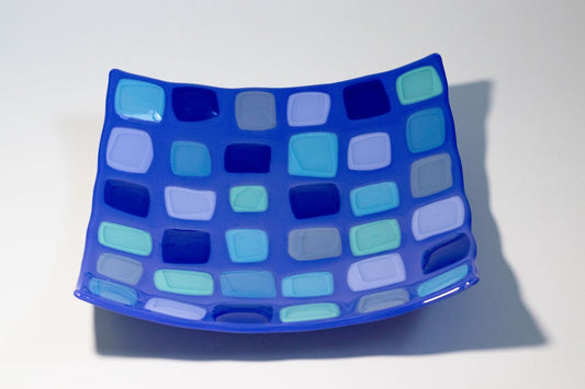 square blue glass bowl with multicolored squares of blue  on top