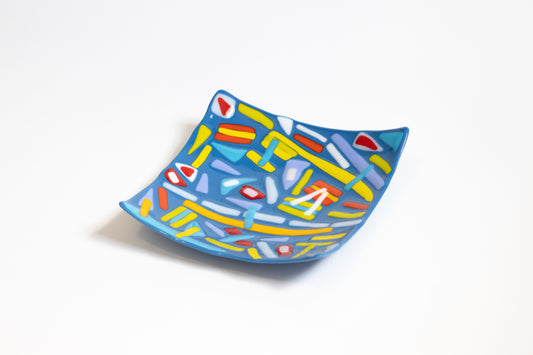 blue glass bowl with yellow, red, white, and blue on top