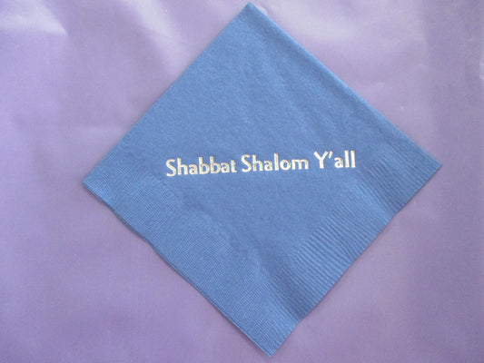 Blue cocktail napkin with silver Shabbat Shalom Y'all slogan