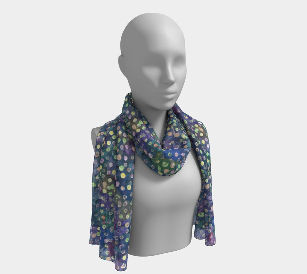 Mannequin wearing scarf with blue, green and purple swirl background with yellow, green and pink dots