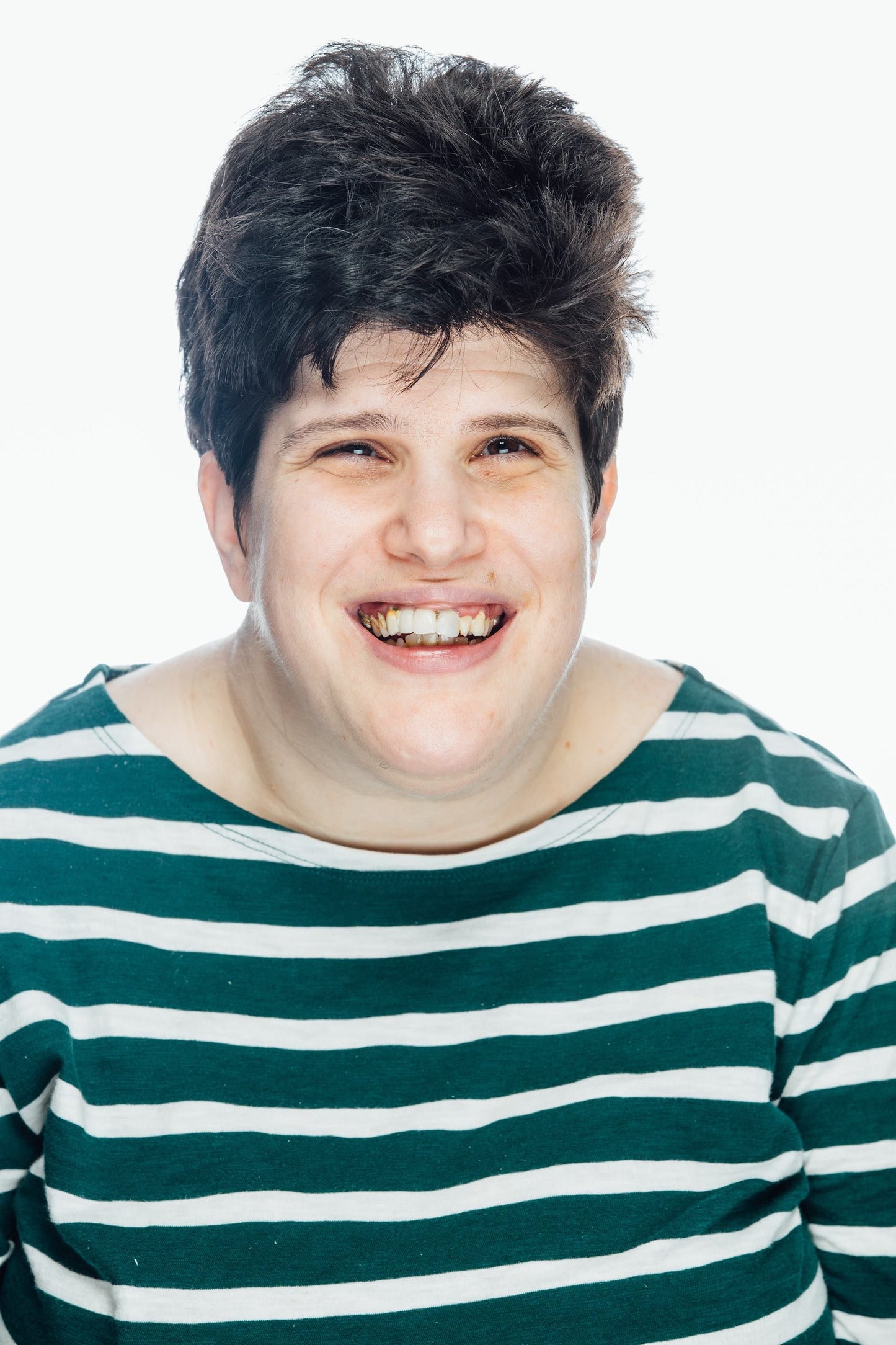 young lady with short dark hair, smiling, wearing a green striped shirt