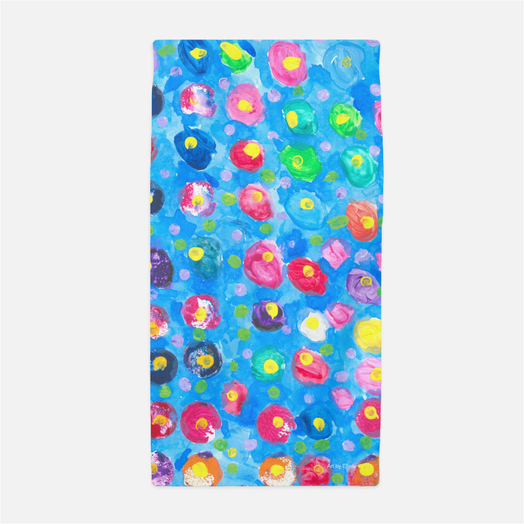 This is a beach towel  with a blue background and multicolored dots with yellow centers. The colors include: purple, pink, orange, and blue.