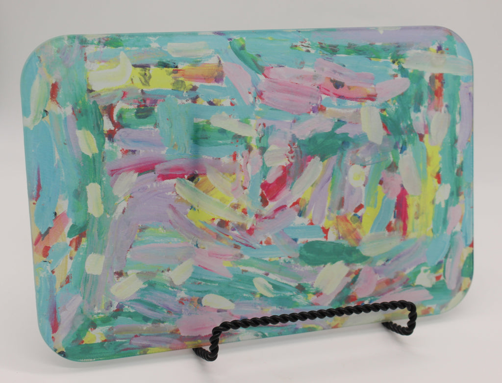 Rectangular glass cutting board depicting pink, turquoise, lavender, green and yellow paint streak design