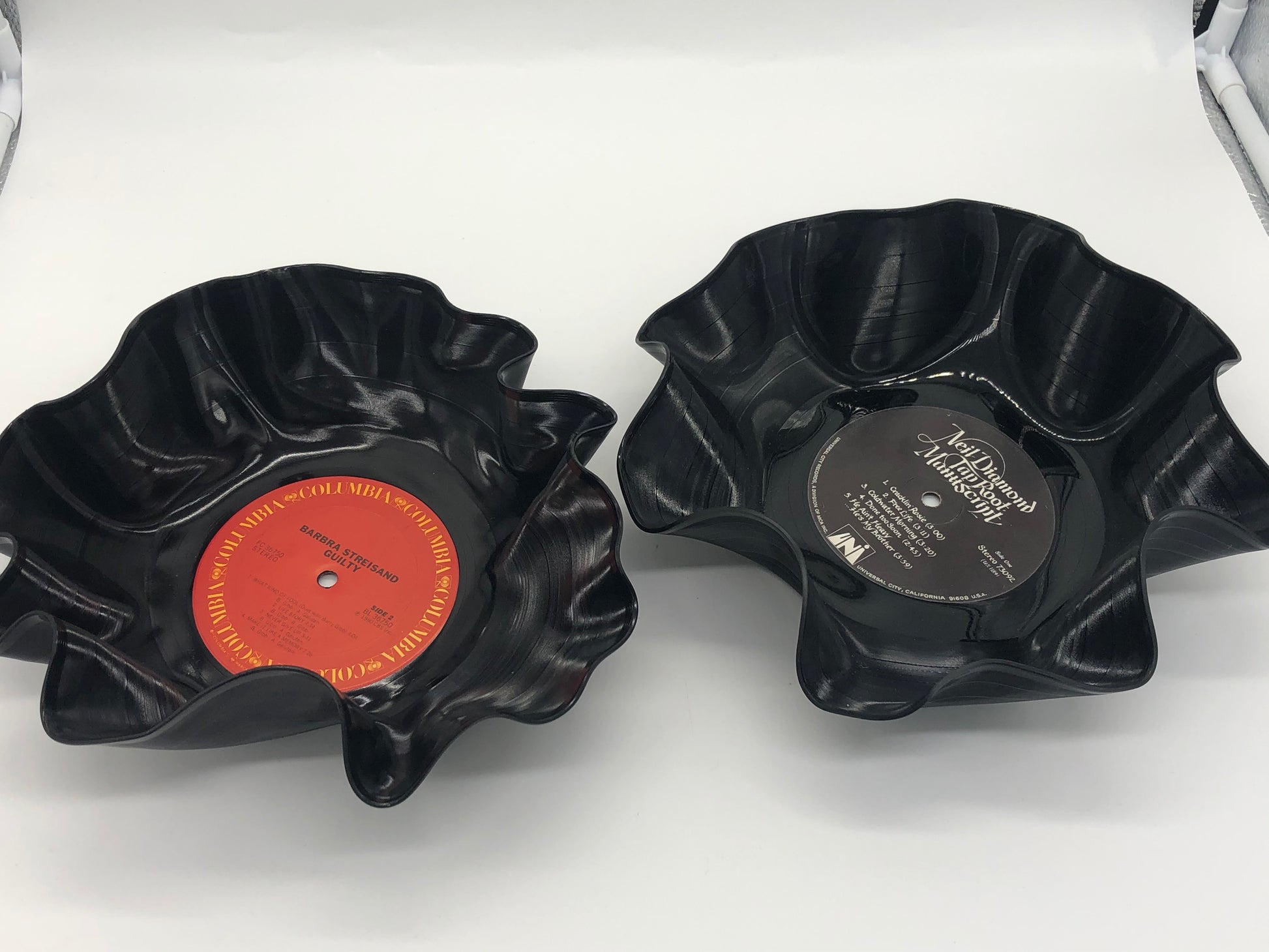 Two black bowls with ruffled edges made from melted records