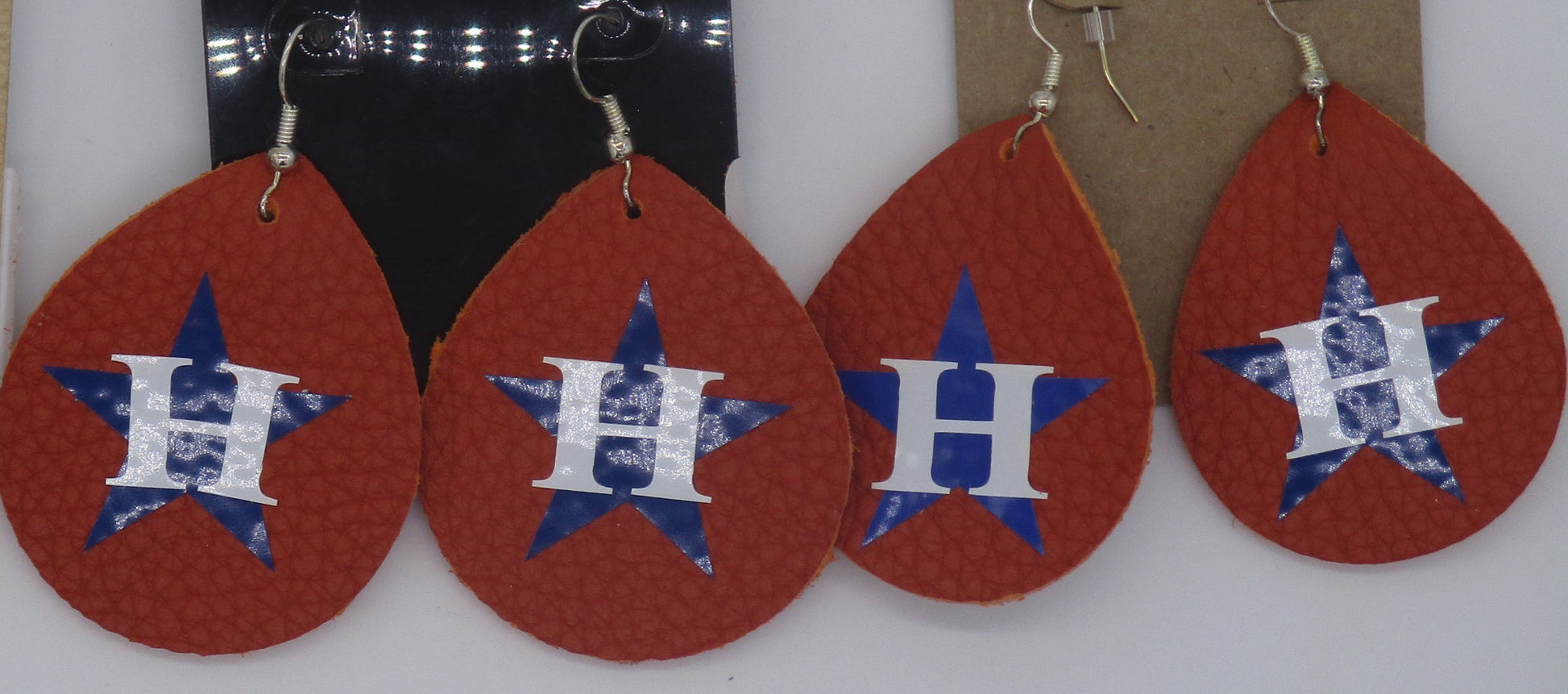 Tear drop shaped orange leather earrings with Houston Astros logo