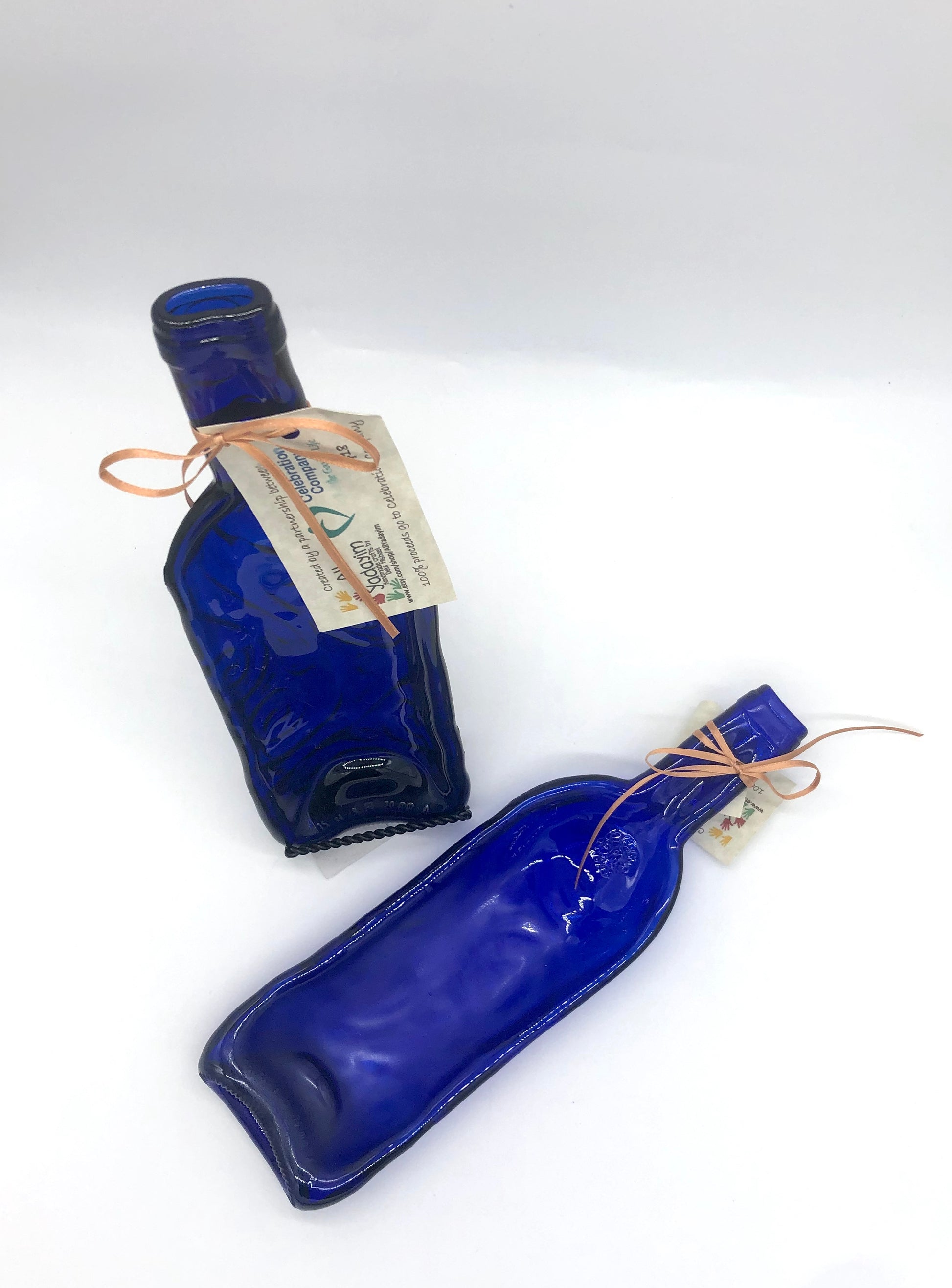 Two blue wine bottles that have been melted down and flattened