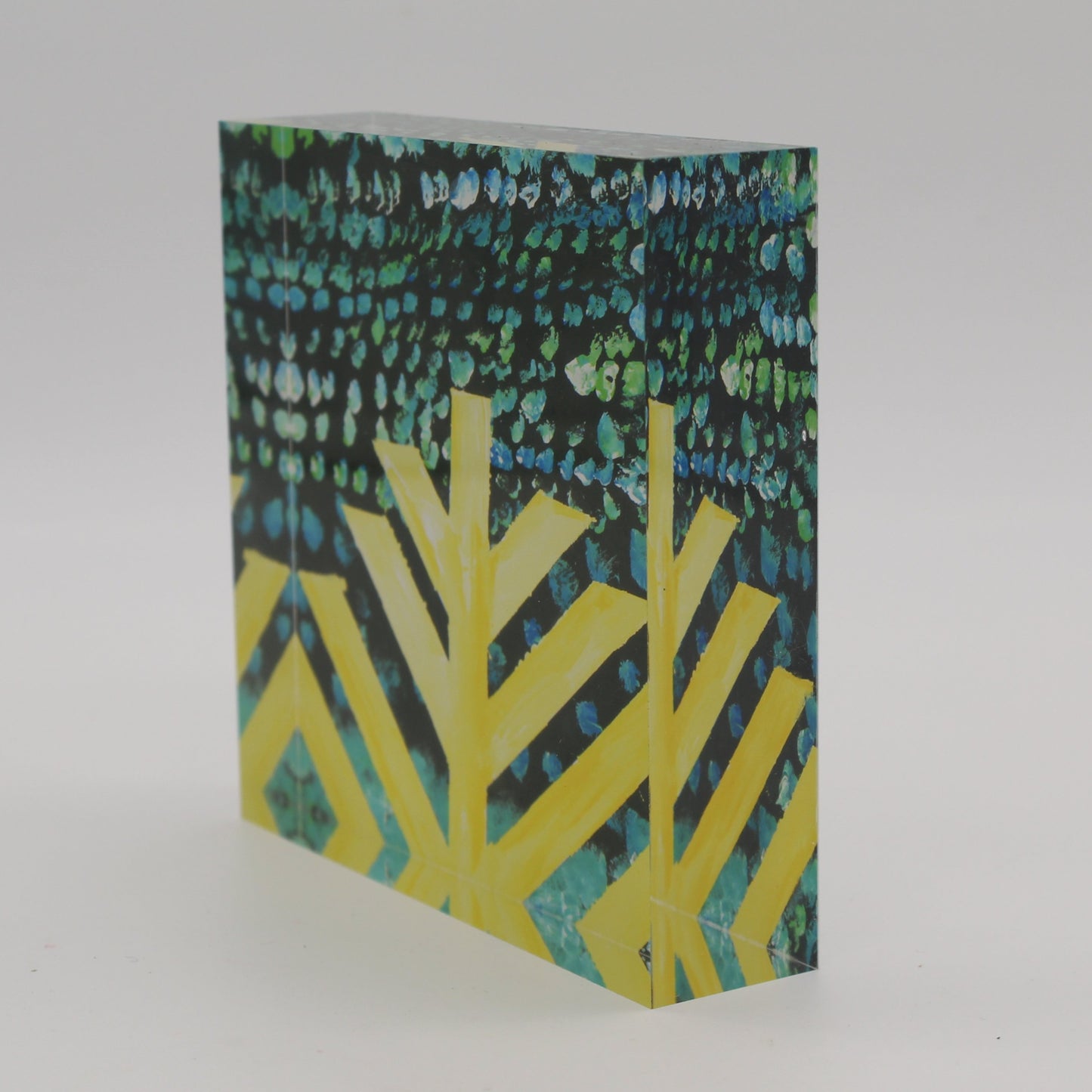 Tilted view of Acrylic block with black background, yellow menorah, and blue, turquoise and green dots