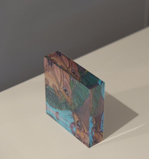 Side view of Acrylic block depicting a small mouse on a grassy area looking into his reflection in the water
