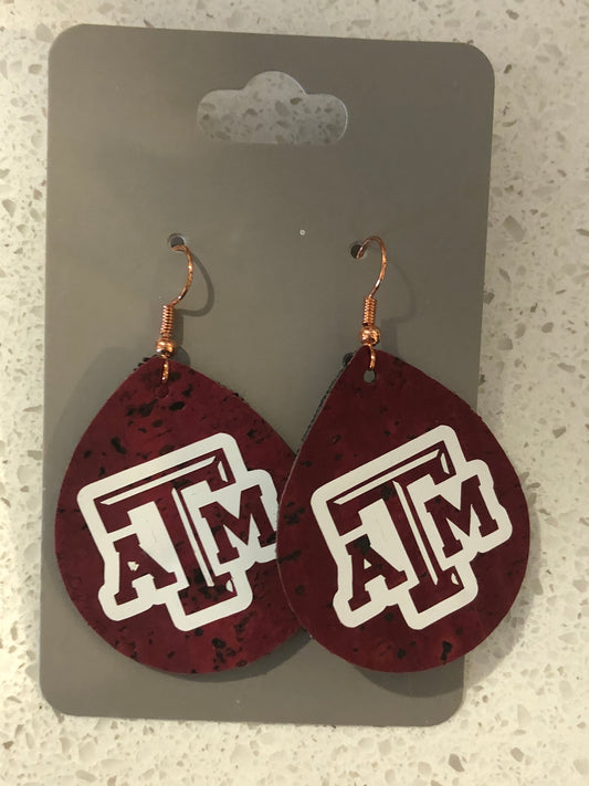 Tear drop shaped maroon leather earrings with A&M logo