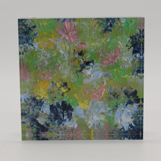 Acrylic block depicting spring flowers of pink, dark and light blue, green and yellow