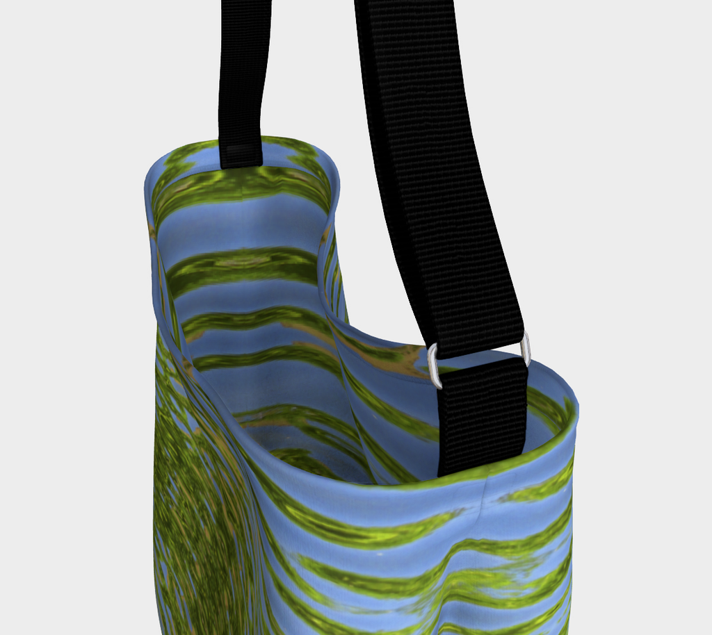 Close up view of Crossbody tote with black strap depicting reflecting water and leaves