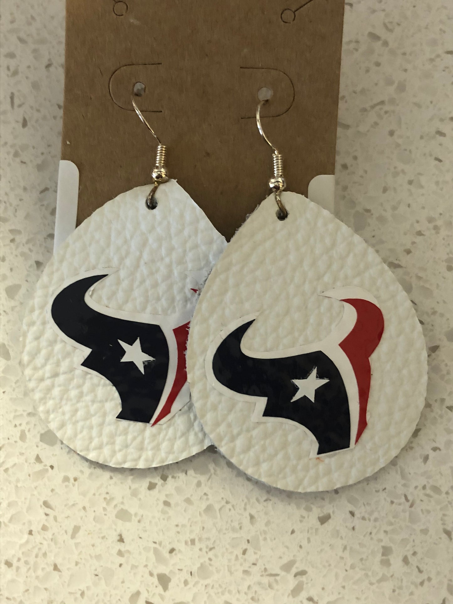 Tear drop shaped white leather earrings with Houston Texans logo