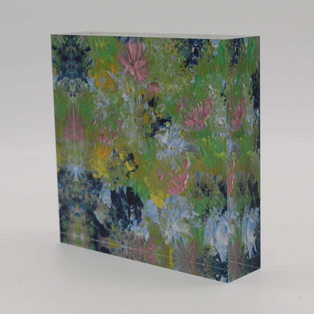 Tilted view of Acrylic block depicting spring flowers of pink, dark and light blue, green and yellow