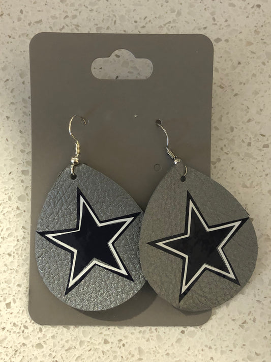 Tear drop shaped silver leather earrings with Cowboys logo