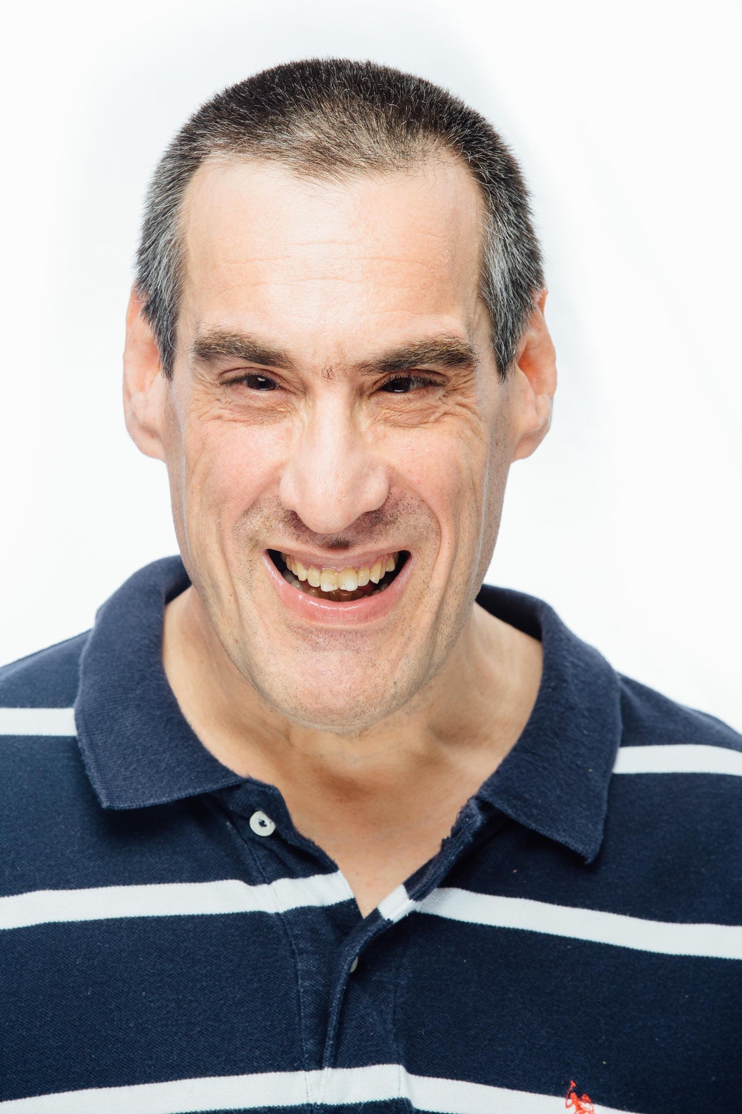 Man wearing blue striped shirt smiling