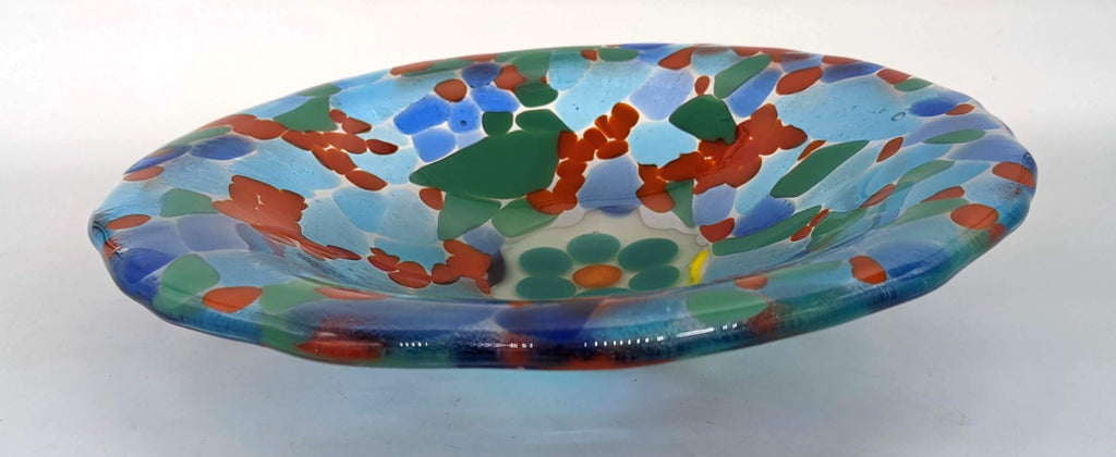Clear glass bowl made of mostly blues. in the center is an image of a flower