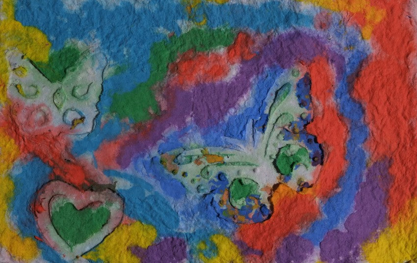 Pigment on recycled paper artwork with blue, green, red, purple and yellow background with two white butterflies and one white heart over top