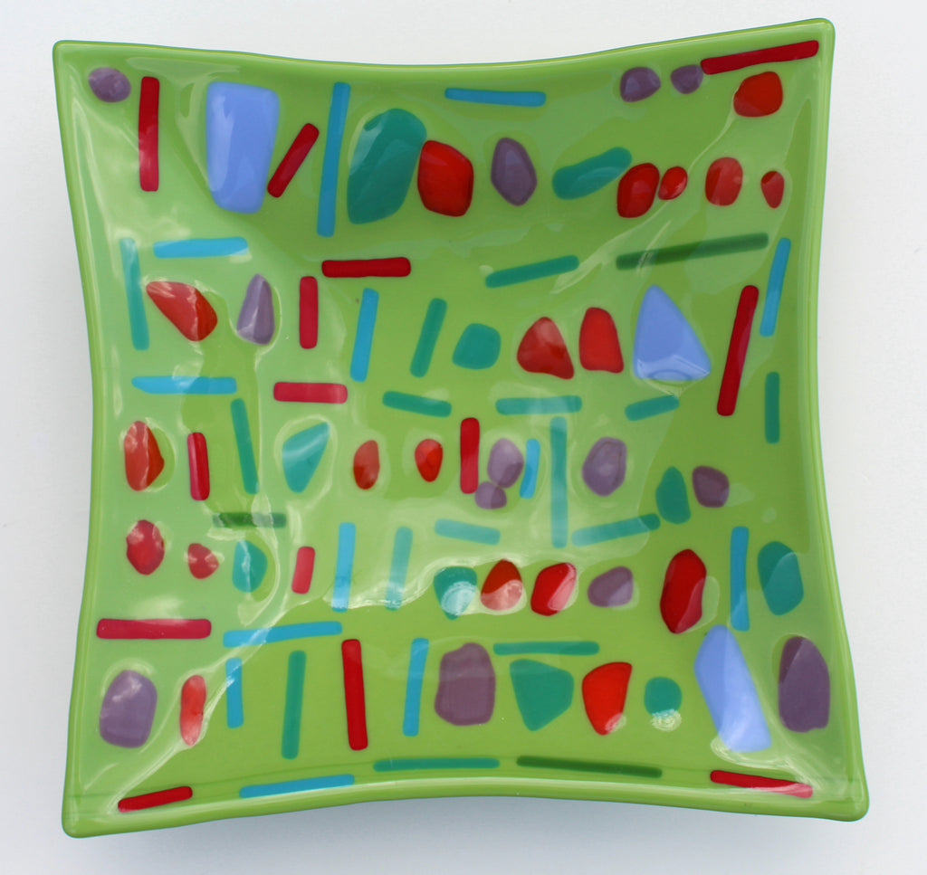 This is a green square glass artwork with blue, red and purple abstract blobs and lines