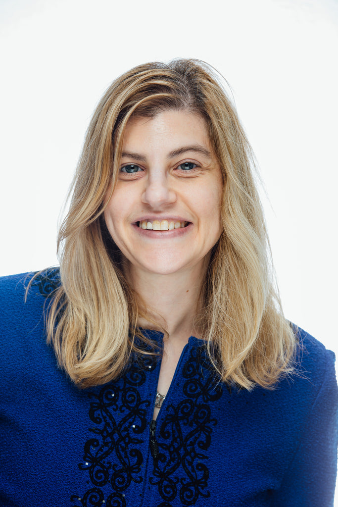 photograph of lady smiling with long blonde hair and wearing a royal blue suit jacket