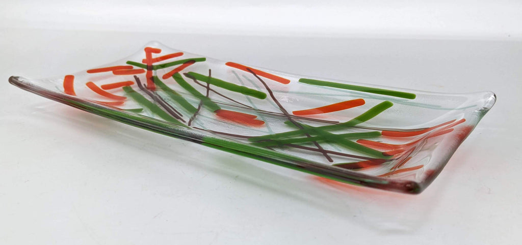 clear glass tray with overlapping lines of orange, green, and brown