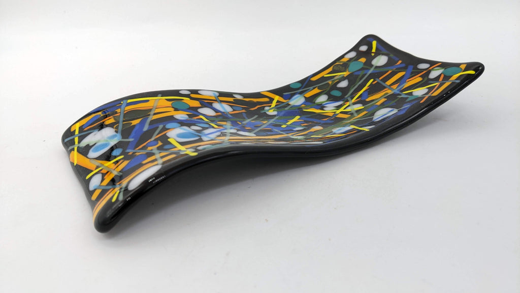 black s curved spoon rest with yellows, blues, and white