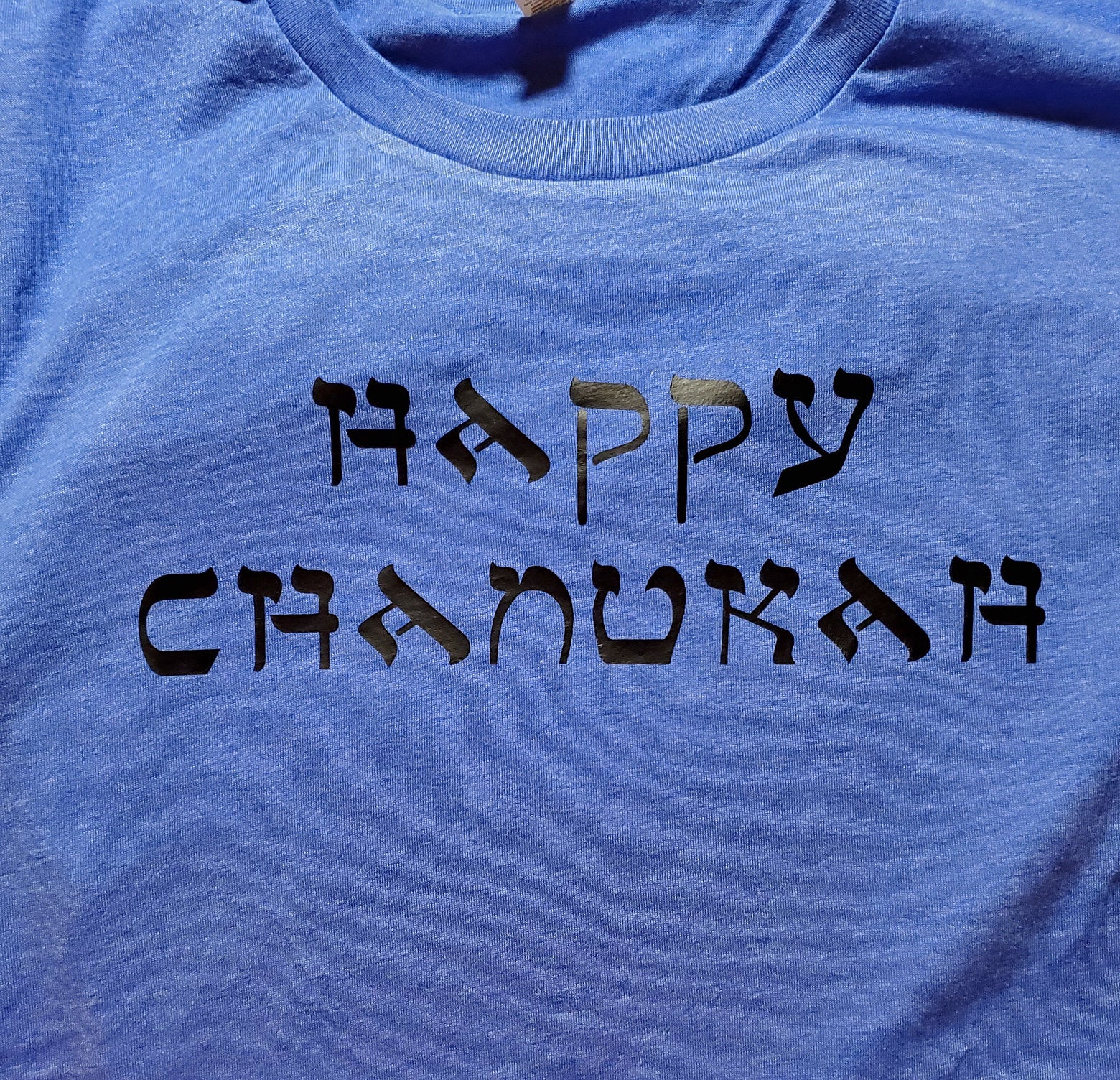 Light blue tshirt with black Happy Chanukah slogan