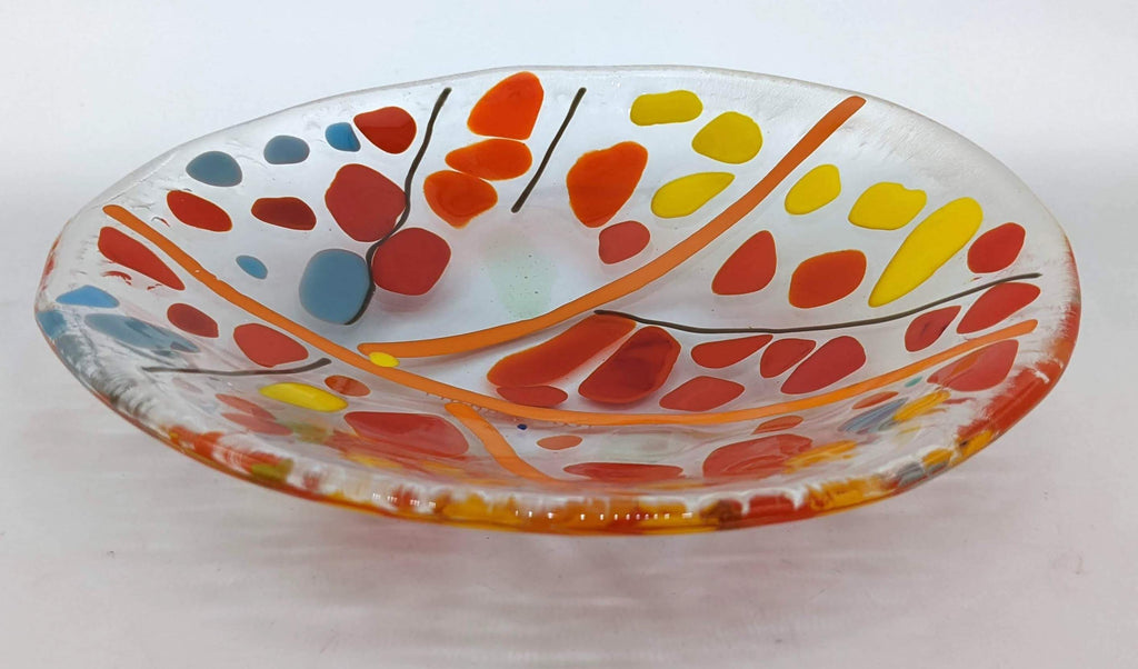 Clear glass bowl with orange lines and spots of red, orange, yellow, and blue