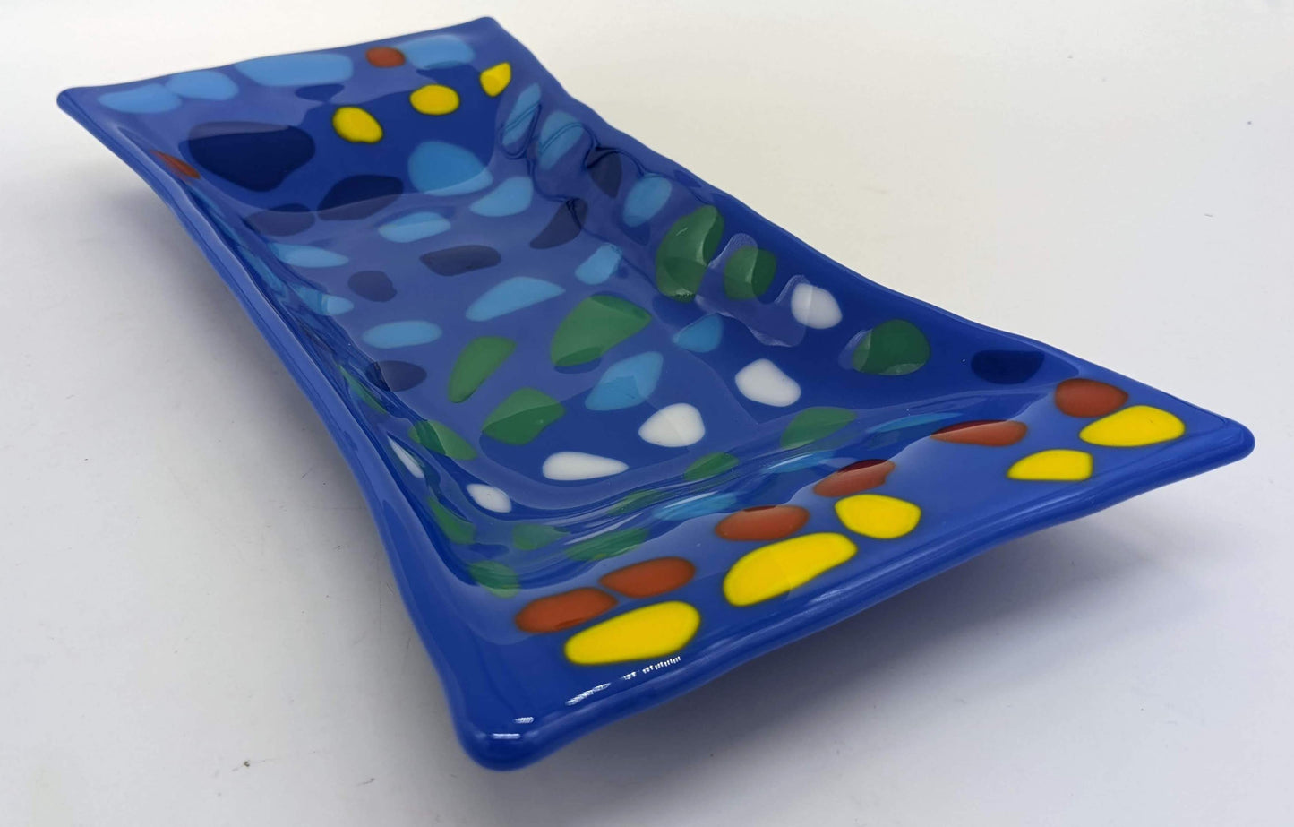 blue glass tray with rows of spots of yellow, white, red, blues, and green