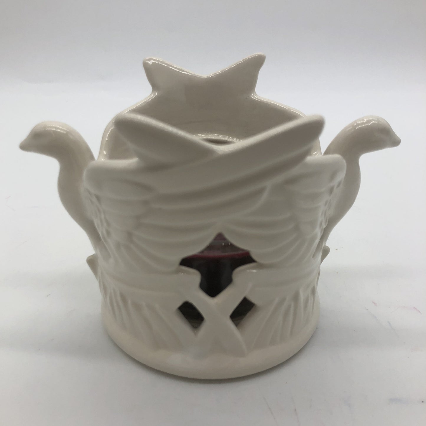 Ceramic votive holder made of two doves in white and small votive candle inside.