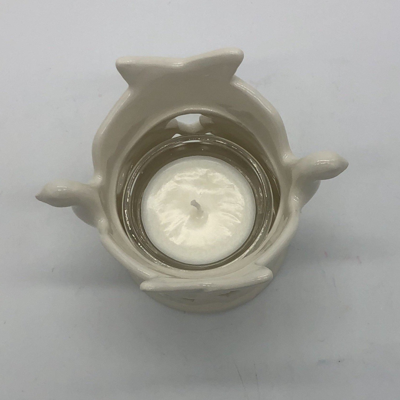 Top view of ceramic dove votive holder with white votive candle inside.
