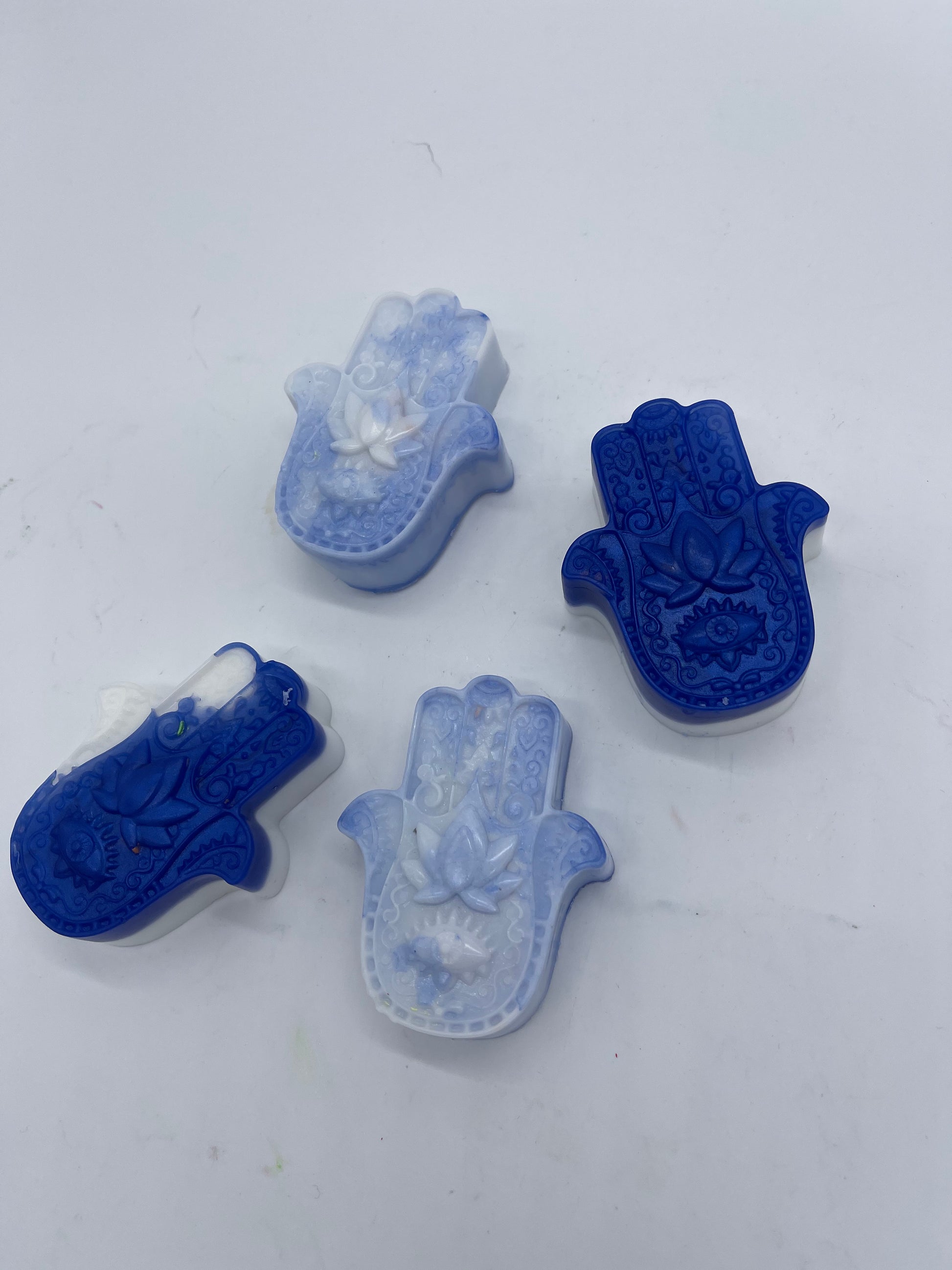 soaps shapes in form of hamsa. Colors vary between bright swirls or blue and white combo swirls