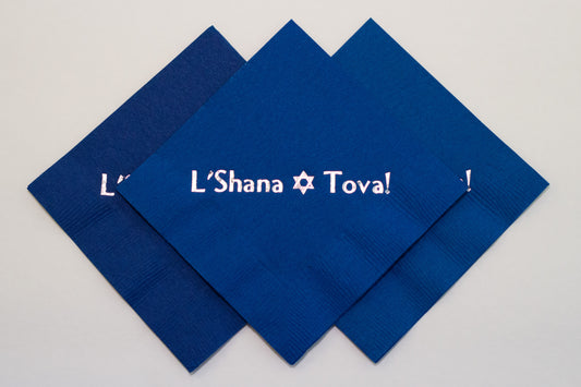 Blue cocktail napkin with silver L'Shana Tova slogan and Jewish star
