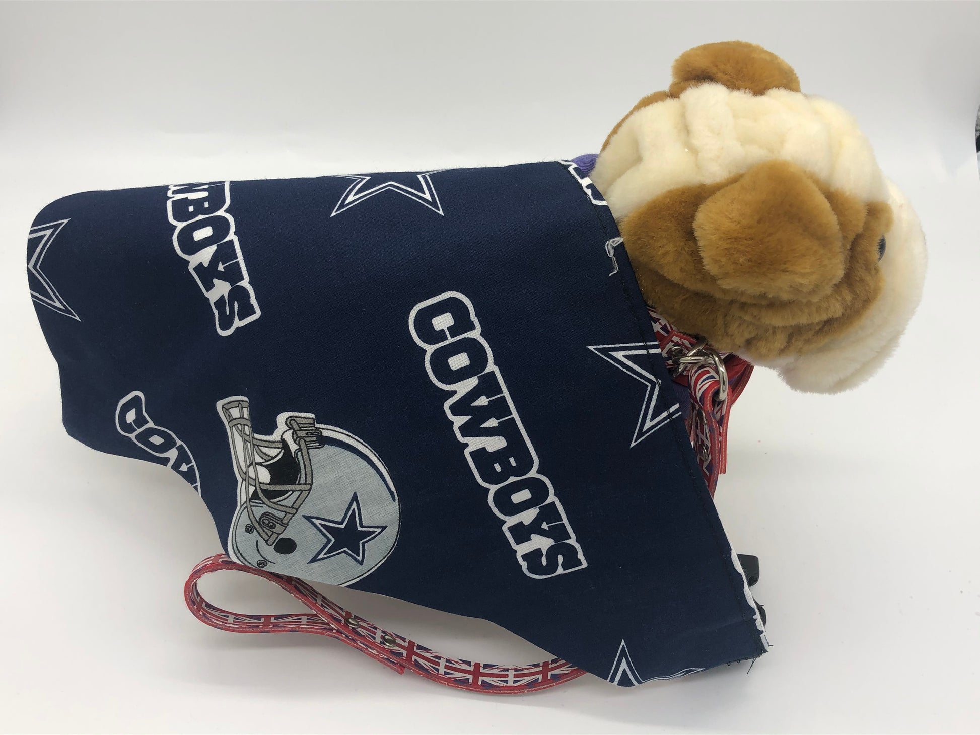 Photo of a small stuffed brown and cream dog with a Navy and grey triangular bandana with the Cowboys logo, star and helmet across it's back.