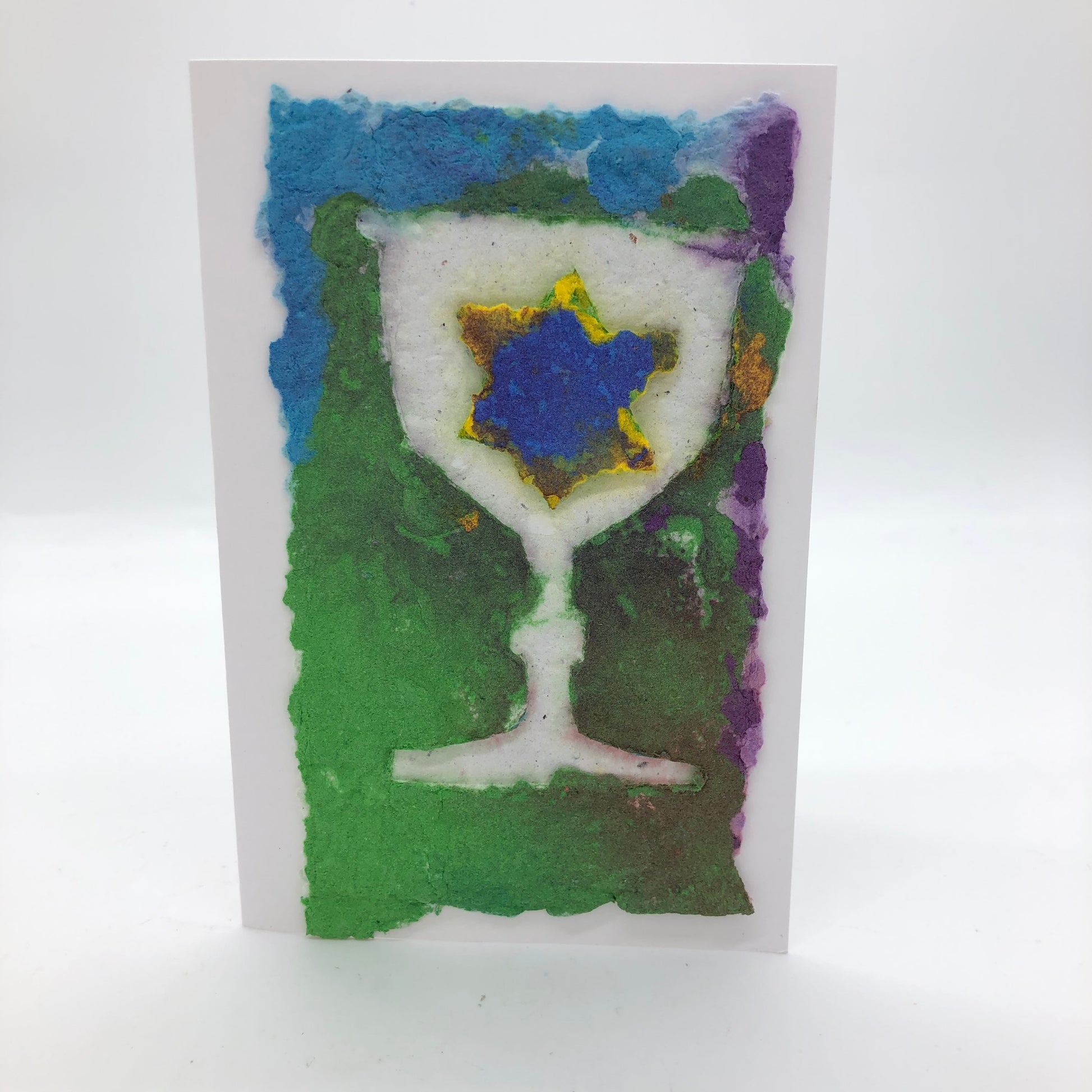 Handmade paper greeting card with white Kiddush cup and yellow/blue Jewish star against green, purple and light blue background
