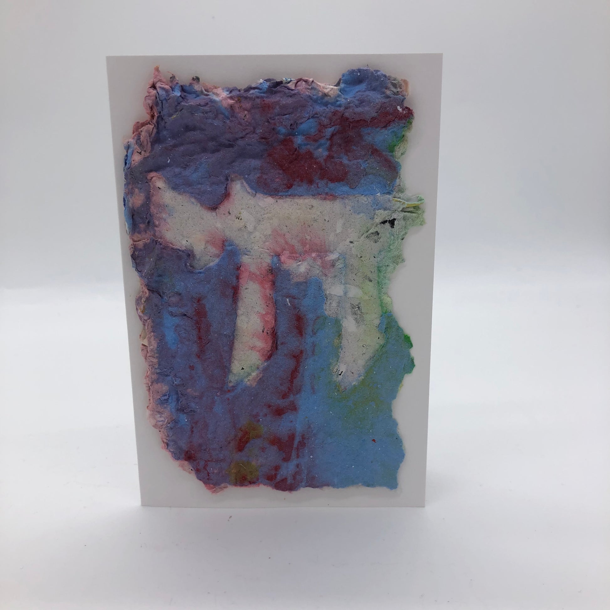 Handmade paper greeting card with white Chai against light blue mixed with maroon background