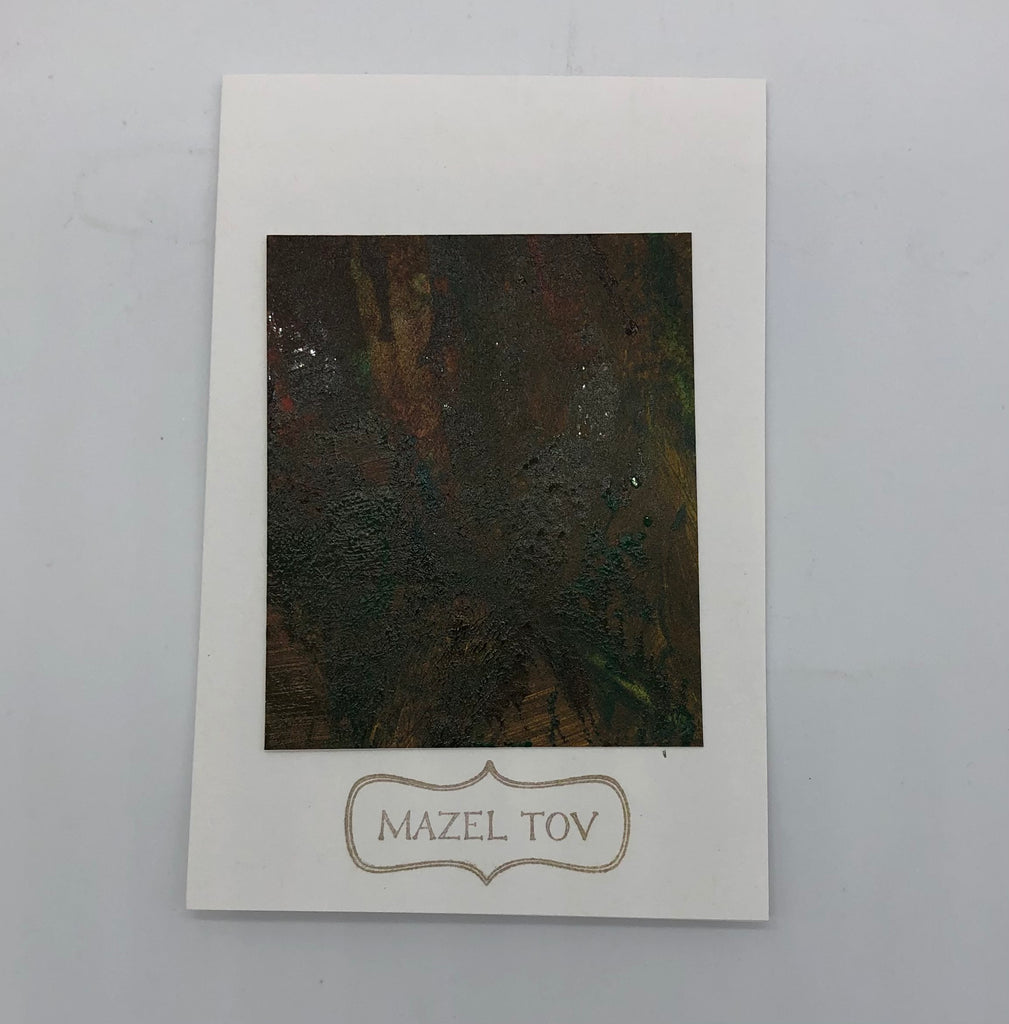 White greeting card with a square of dark acrylic painting.  Painting is is maroon, yellow mixed in and brown.  Under art is Mazel Tov stamped inside a decorative frame.