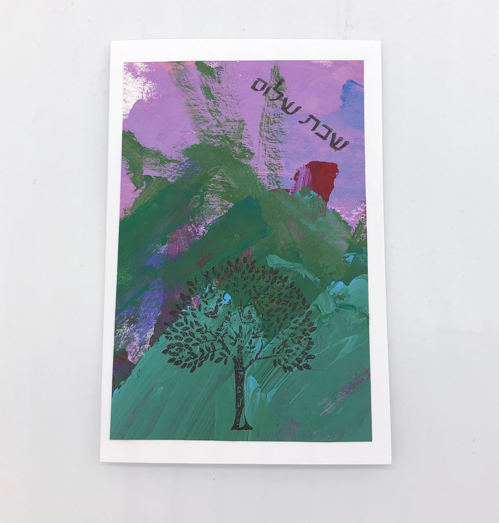 painted background in lavender and green with a little bit of red and blue.  THere is a stamped tree at the center bottom and Hebrew  words stamped at the top.